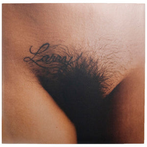 One of two full-color pockets in Larry Clark's C/O Berlin publication. A close-up image of a tattoo that says "Larry" above an area of pubic hair. 