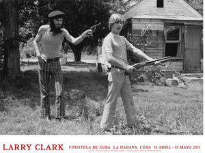 Poster from Larry Clark's 2011 exhibition in Cuba, white a black and white photo of two male figures with guns.