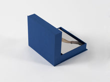 Load image into Gallery viewer, Image of interior of boxed set by Michelangelo Pistoletto with silkscreen on steel and book with cover halfway closed and visible.