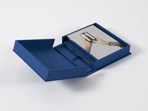 Image of interior of boxed set by Michelangelo Pistoletto with silkscreen on steel and book, cover closing.