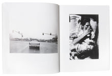 Load image into Gallery viewer, Image of the inside of the photograph book from Larry Clark&#39;s &quot;Kiss the Past Hello&quot; set. Image on the left page is of a car at a stop light, image on the right is of a man laying in bed smoking a cigarette with a baby laying on his stomach.