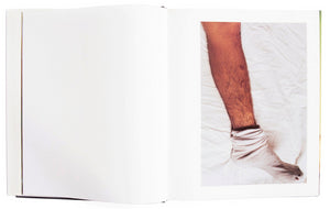 Interior view of Larry Clark's "The Perfect Childhood", with photograph of socked foot on sheet.